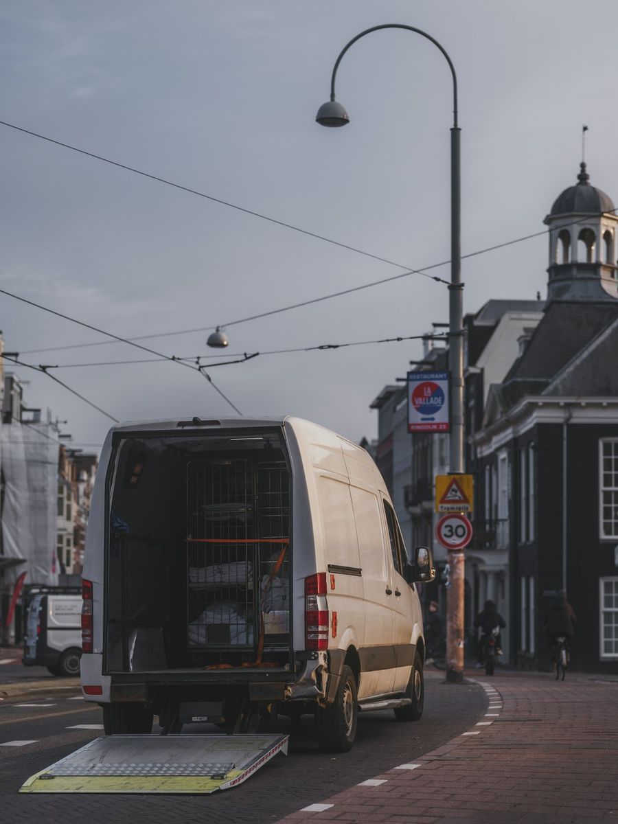 Delivery van parked on a city street with doors open